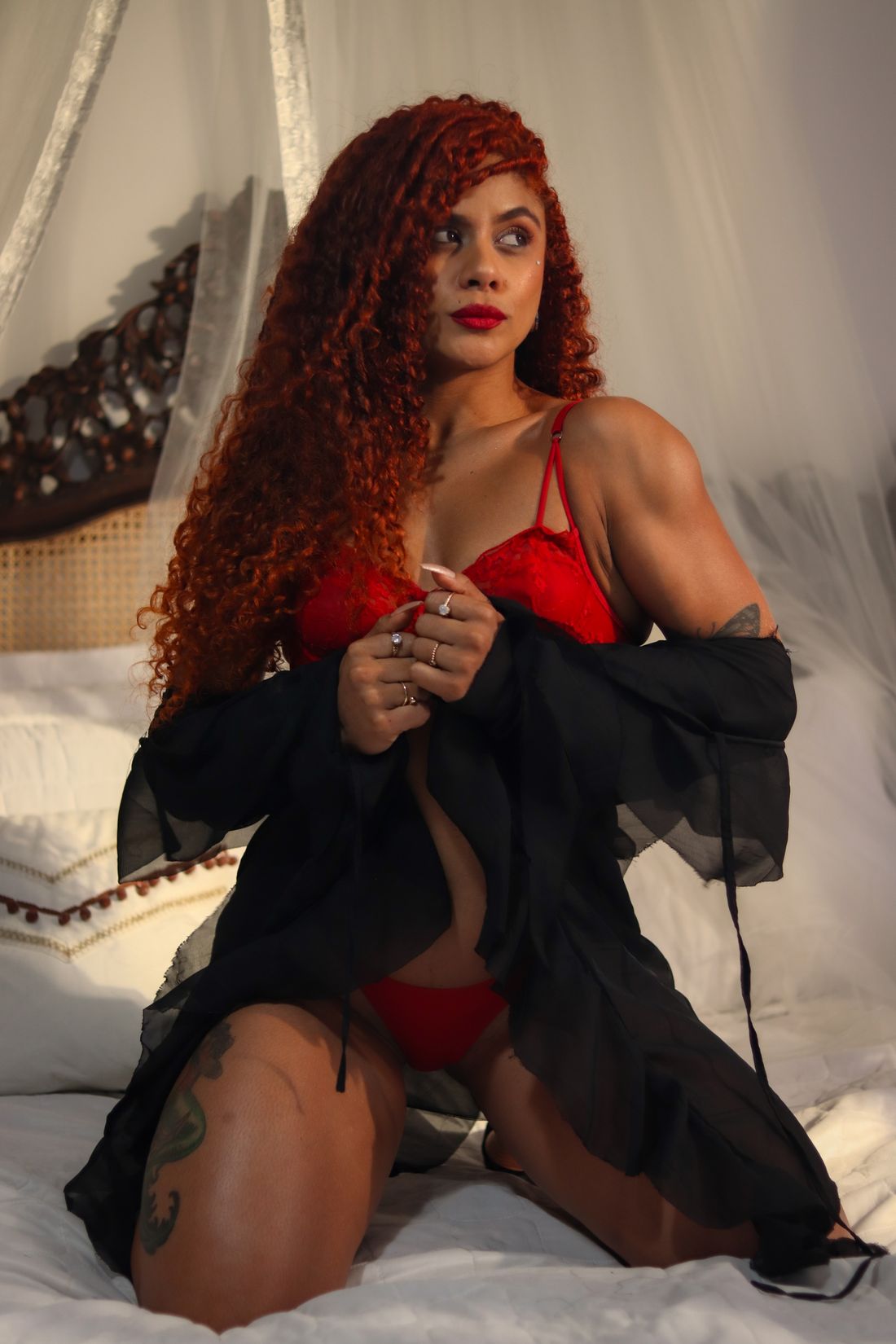 Modelo segurando o robe preto fechado sobre a lingerie